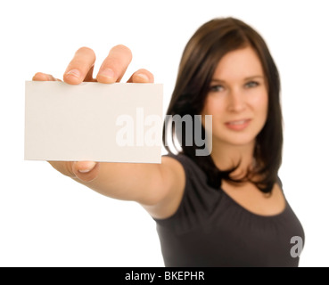 A brunette woman holds a blank, horizontal, business card at arm's length. Focus is on the card, with face out of focus. Stock Photo