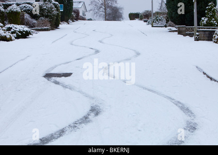 Skid marks in the snow from a car on a steep road in Ambleside UK Stock Photo