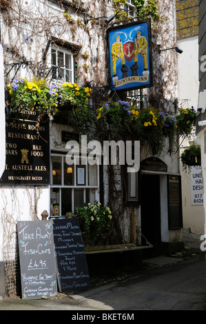 Exterior of an English pub decorated with flowers and advertising boards The Fountain Inn at Mevagissey Cornwall UK Stock Photo