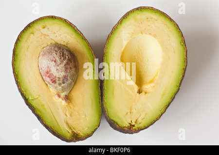 Avocado cut in half with the seed in Stock Photo