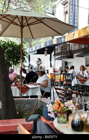 outdoor diners enjoy spring evening & bustling congenial sidewalk cafe scene Plaza Luis Cabrera in Roma district of Mexico City Stock Photo