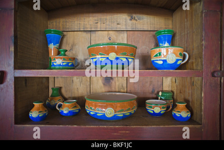 Brilliant blue Mexican pottery graces an antique wood cupboard, in the ski resort town of Ruidoso, New Mexico. Stock Photo