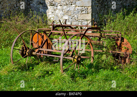 rusty farm machinery in corner of field. Stock Photo