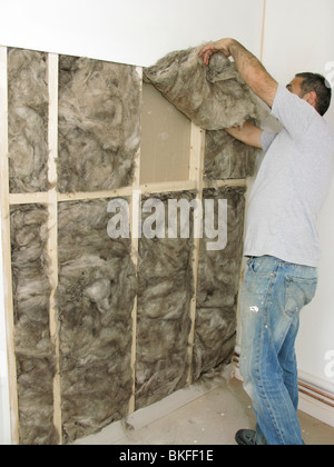 worker placing Earthwool Carbon zero loft & cavity insulation used to save energy & help the environment in a cavity wall Stock Photo