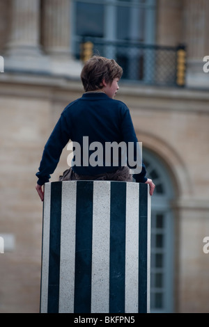 Palais Royale Gardens, Jardins, Children Playing in Park, 'Colonnes de  Buren' Modern Sculpture Installation, Paris, France, boy sitting from behind Stock Photo