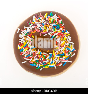 Chocolate Doughnut with vibrant multicoloured sprinkles isolated against white. Stock Photo