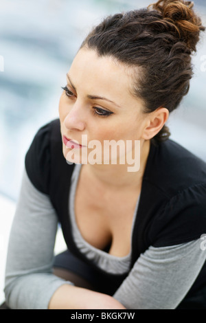 caucasian woman sitting outdoors and looking away Stock Photo