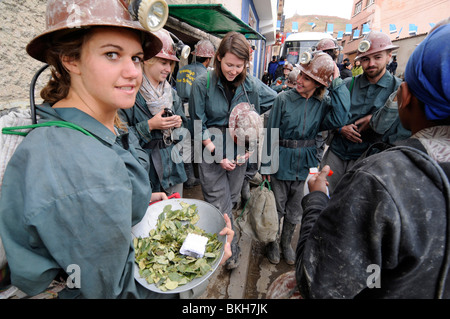 Tourists dressed buying gifts for miners (drinks, coca leaves) before visiting the  mines of the Cerro Rico in Potosi, Bolivia. Stock Photo