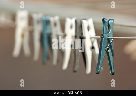 Row of plastic cloths pegs on the cloths line. Stock Photo