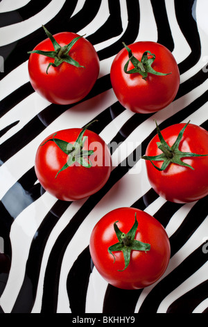 Five tomatoes on striped plate