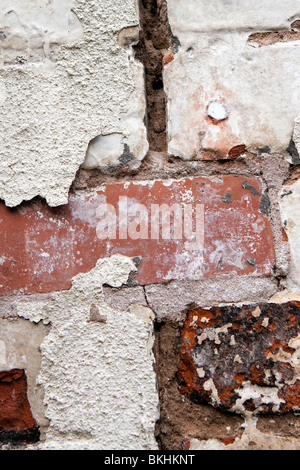 house maintenance flaking paint on old brickwork in need of repointing and painting Stock Photo