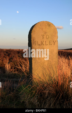 The moon rises over a stone signpost or milestone on 'Rombolds' or Ilkley Moor, in West Yorkshire, England, UK Stock Photo