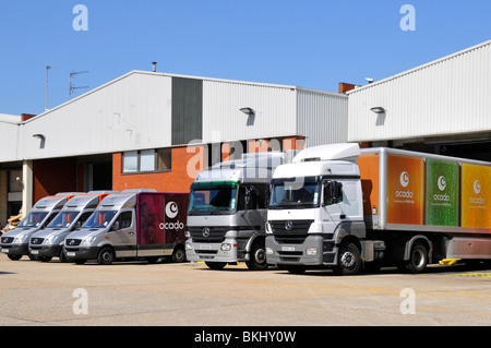 Ocado online supermarket business with Mercedes delivery vans and lorry trucks outside distribution depot warehouse building West London England UK Stock Photo