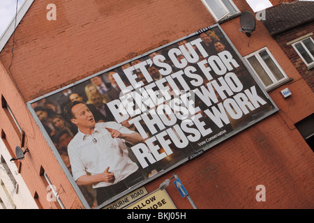 Vote Conservative Tory campaign billboard poster featuring David Cameron saying lets cut  benefits for those who refuse work Stock Photo