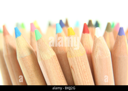 A close-up photograph of pencil brightly coloured crayons pointing upwards at an angle, lit brightly. Stock Photo