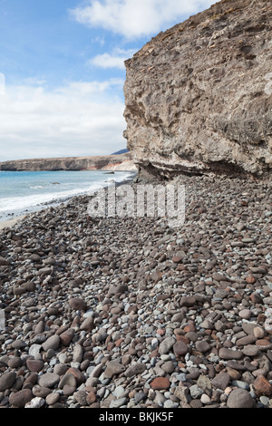 A beach of volcanic rock pebbles near the harbour at Morro del Jable, on the Canary island of Fuerteventura Stock Photo