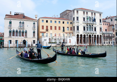 Two traditional traghetto public ferry gondolas ferrying people across Grand Canal in Venice Italy Stock Photo