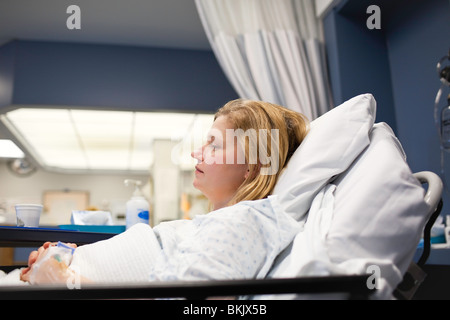 Woman recovering in a hospital room bed.