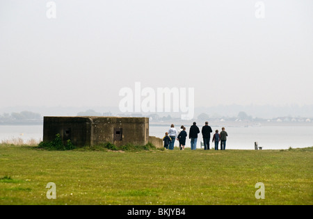 Families walking past the remains of a World war II pillbox in Essex Stock Photo