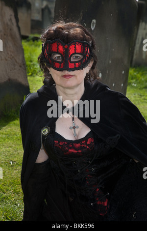 Woman in Red Mask in Graveyard at Whitby Goth Festival, April 2010, Stock Photo