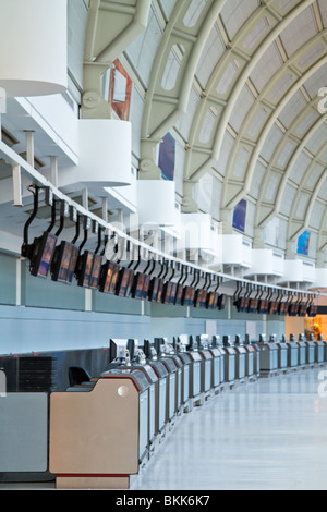 A row of airport check-in counters, with lcd monitors above. Stock Photo