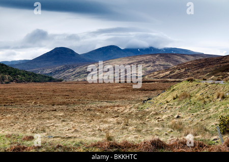 Glen Cassley, Sutherland, Scotland on a bright, spring day showing flat valley floor and cloud topped mountains in the distance Stock Photo