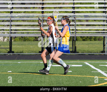 Girls high school lacrosse game. Face off running passing blocking. Teenage girls sports. Stock Photo