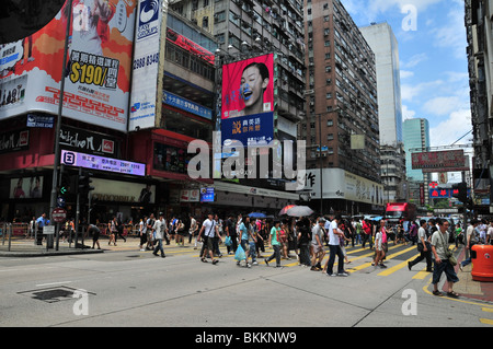 Large number of pedestrians crossing the road at traffic lights, looking east, along Argyle Street, Mong Kok, Kowloon, Hong Kong Stock Photo