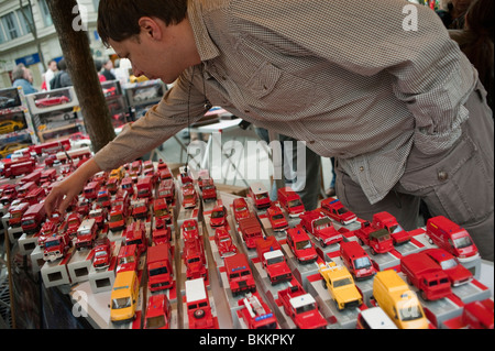 Man Shopping for 'Second Hand' Children's TOy Cars on Street Garage Sale, Paris, France, Vintage toys Stock Photo