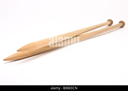A pair of large wooden knitting needles from low perspective isolated against white background. Stock Photo