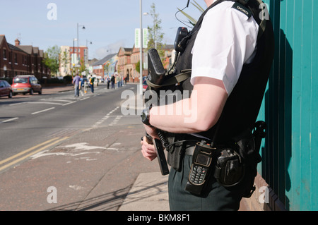Armed police officer standing on the Falls Road, policing a 'White Line Picket' Stock Photo