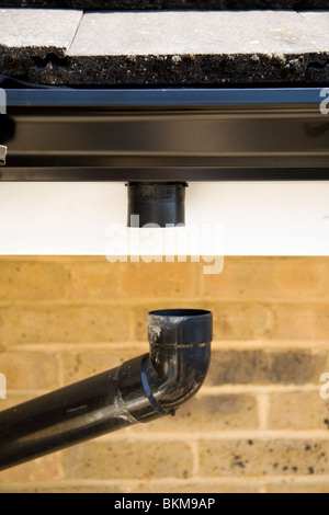 Down pipe / downpipe drain that's come away from a gutter on an apartment block, which can cause damp / drips / water leak. UK. Stock Photo