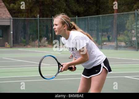 A high school tennis player on the varsity team at a tennis match Stock Photo