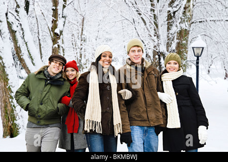 Group of diverse young friends walking outdoors in winter park Stock Photo