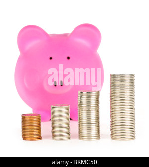 Stacks of coins in front of pink piggy bank showing growth Stock Photo