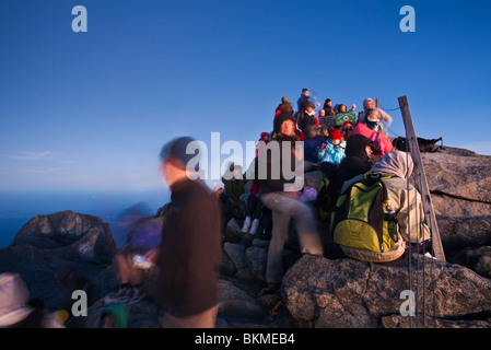 Climbers crowd the summit of Mt Kinabalu at Low's Peak, at dawn. Kinabalu National Park, Sabah, Borneo, Malaysia. Stock Photo