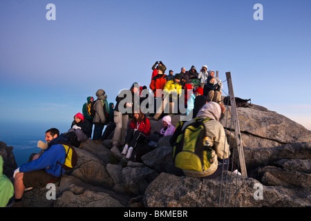 Climbers crowd the summit of Mt Kinabalu at Low's Peak, at dawn. Kinabalu National Park, Sabah, Borneo, Malaysia. Stock Photo