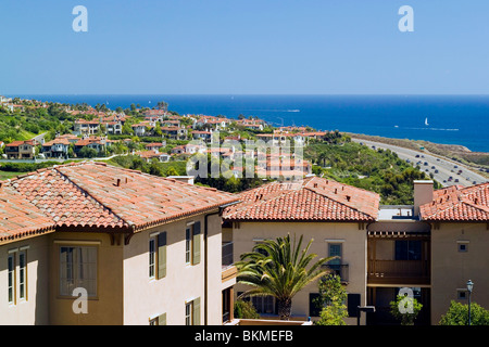 Newport Coast Mediterranean-style homes with red-tile roofs overlook Pacific Coast Highway and the Pacific Ocean at Newport Beach, California, USA. Stock Photo