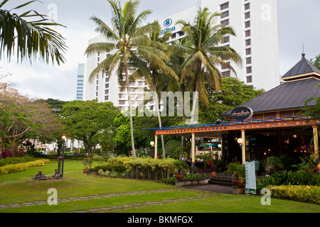 The James Brooke Bistro and Cafe on the waterfront with the Hilton Hotel in the background. Kuching, Sarawak, Borneo, Malaysia. Stock Photo