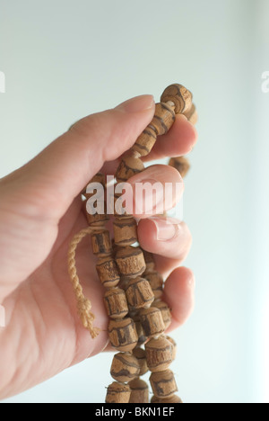 Woman hand holding 108 Tibetan Wooden Yoga Meditation Prayer Beads Mala Necklace Stock Photo