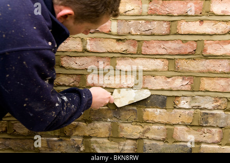 A brick wall being re-pointed / pointing a wall. Stock Photo