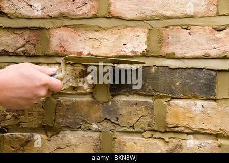 A brick wall being re-pointed / pointing a wall. Stock Photo