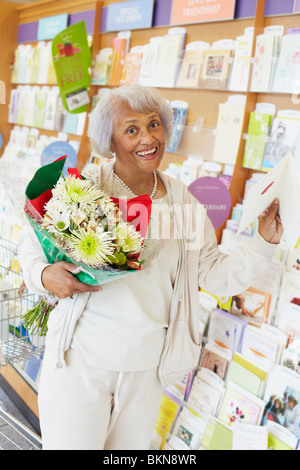 Senior African American woman buying flowers and greeting card
