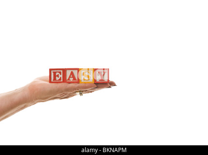 Woman holding children's blocks that spell 'EASY' Stock Photo