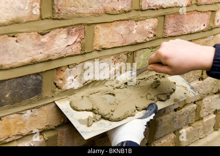 A brick wall being re-pointed / pointing a wall. Stock Photo