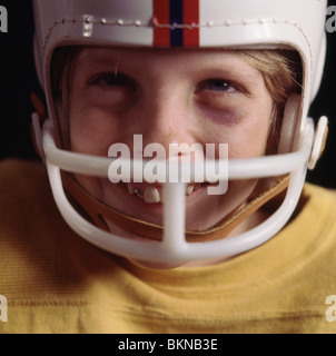 Close-up of a young boy wearing an old football helmet Stock Photo