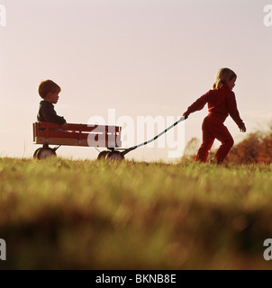 Brother and Sister Playing in Wagon Stock Photo - Alamy