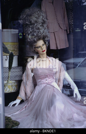 Female mannequin with beehive hairstyle wearing an evening gown in a thriftshop window. Stock Photo
