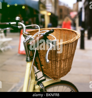 A wicker basket and handlebars (handle bars) of a vintage bicycle parked in the street in Camden Passage in London England UK  KATHY DEWITT Stock Photo