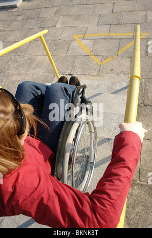 Closeup of wheelchair woman going down the concrete stairs Stock Photo